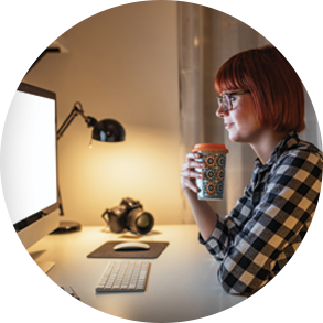 woman with drink in front of computer